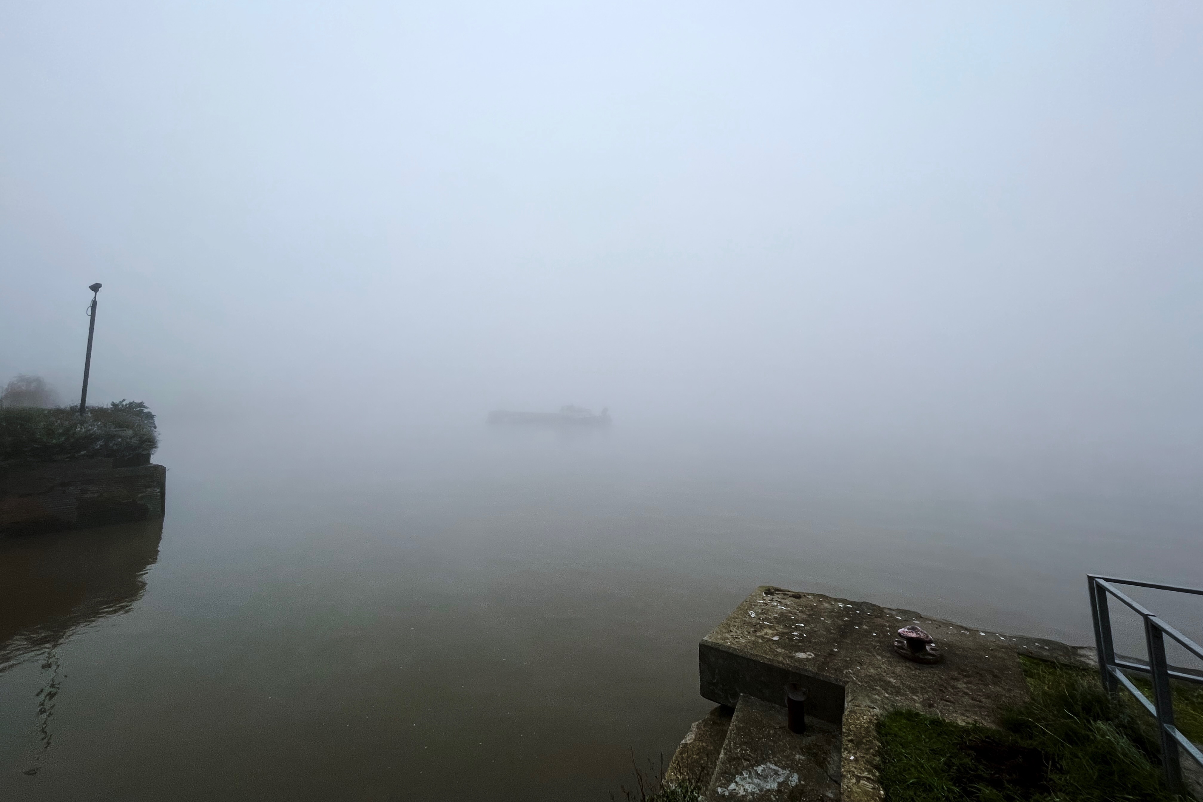 The Thames in the fog showing a barge faintly visible in the middle of the river